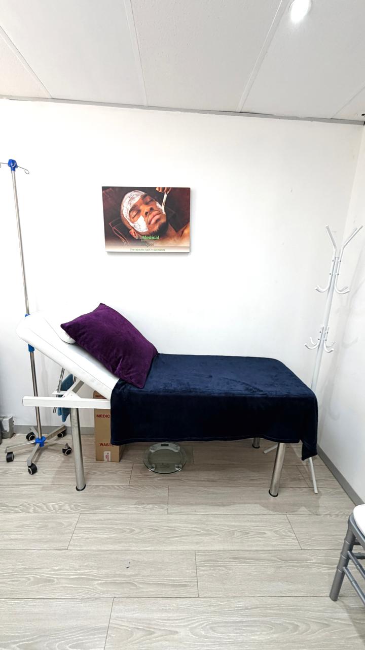 Lonehill consultation room with examination bed, IV stand and skincare treatment poster
